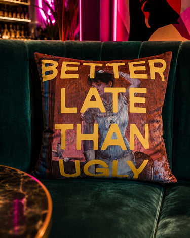 Better Late Than Ugly slogan velvet cushion styled on a sofa