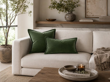 Green velvet cushion styled on a sofa