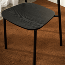 Close-up of the Olly dining chair's black ash seat