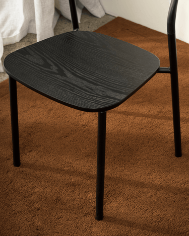 Close-up of the Olly dining chair's black ash seat