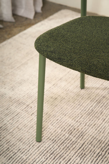 Close-up of the Olly dining chair's olive green boucle seat
