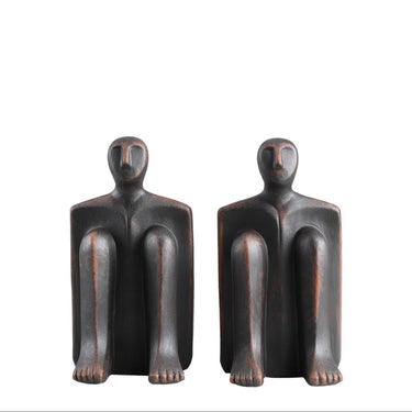 Sitting Man Bookends, a pair of seated-figure sculptures cast in solid cement with a matte charcoal finish