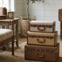 Vintage Trunk Set of 3 stacked beside a chair in a farmhouse living room