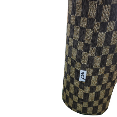 A close-up of a cylindrical product featuring a dark brown and beige checkerboard pattern, with a small white tag reading 'ned' on the side, set against a plain white background.