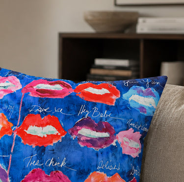 Lips on blue velvet cushion styled on a sofa
