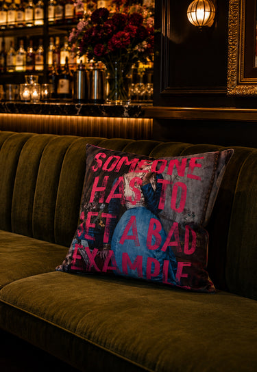 Bad Example slogan velvet cushion styled on a sofa