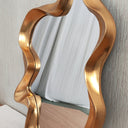 Gold abstract mirror styled on a wall