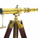 Handmade golden brass spyglass telescope resting on a handcrafted wooden tripod