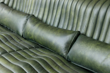 Cuban 3 Seater Leather Sofa in olive with a sculptural channel-ribbed silhouette and dark metal base
