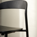 Close-up of the Olly dining chair's curved black backrest