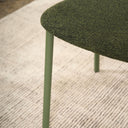 Close-up of the Olly dining chair's olive green boucle seat