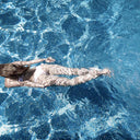 Splash glass wall art, overhead photograph of a swimmer in blue water